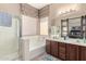 Bright bathroom featuring a dual vanity, large tub, shower, and decorative barn door at 45140 W Zion Rd, Maricopa, AZ 85139