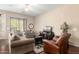 Spacious living room with hardwood floors, comfortable seating, and a sliding glass door to the patio at 45140 W Zion Rd, Maricopa, AZ 85139