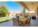 Inviting covered patio with outdoor dining furniture overlooking backyard at 45140 W Zion Rd, Maricopa, AZ 85139