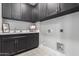 Well-organized laundry room with dark cabinets, modern fixtures, and ample storage space at 5250 E Deer Valley Dr # 243, Phoenix, AZ 85054