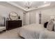Cozy main bedroom featuring neutral colors, a dresser with a round mirror and plenty of light at 5250 E Deer Valley Dr # 243, Phoenix, AZ 85054