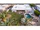 Aerial view of a backyard with a pool, spa, outdoor kitchen, lush landscaping, and mature trees, ideal for entertaining at 5642 E Justine Rd, Scottsdale, AZ 85254