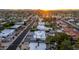 Sunset aerial view of a beautiful neighborhood showcasing a mix of homes with backyard pools surrounded by mature desert landscape at 5642 E Justine Rd, Scottsdale, AZ 85254