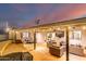 Spacious back patio with outdoor seating, BBQ, and TV, perfect for entertaining at dusk at 5642 E Justine Rd, Scottsdale, AZ 85254