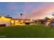 Manicured backyard with a patio area for dining and grilling, a swimming pool, and a lush lawn for recreation at 5642 E Justine Rd, Scottsdale, AZ 85254