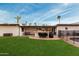Expansive backyard featuring lush lawn, outdoor kitchen, covered patio and pool at 5642 E Justine Rd, Scottsdale, AZ 85254