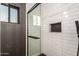 Tiled walk-in shower featuring a glass door and a built-in shower niche at 5642 E Justine Rd, Scottsdale, AZ 85254