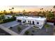 The attractive single-story home has arched windows, a neutral palette, mature palms, and a well-manicured front yard at 5642 E Justine Rd, Scottsdale, AZ 85254