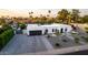 Eye-level, the home boasts mature palms, a neutral palette, arched windows, a well-landscaped yard, and paver driveway at 5642 E Justine Rd, Scottsdale, AZ 85254