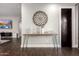Hallway with console table, decorative wall hanging, and view to living room with large screen TV at 5642 E Justine Rd, Scottsdale, AZ 85254