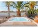 Backyard hot tub with a stone deck and accent fire bowls is surrounded by desert landscaping, including palm trees and cacti at 5642 E Justine Rd, Scottsdale, AZ 85254