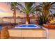 Hot tub surrounded by desert landscaping and accented by fire bowls and dramatic lighting for a serene outdoor experience at 5642 E Justine Rd, Scottsdale, AZ 85254