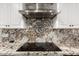 Close-up of kitchen features granite countertops, stainless steel appliances, and stylish range hood at 5642 E Justine Rd, Scottsdale, AZ 85254