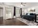Bedroom with ceiling fan, window with curtains, and ensuite bathroom with sliding barn door at 5642 E Justine Rd, Scottsdale, AZ 85254