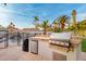 Outdoor kitchen featuring a built-in stainless steel grill, refrigerator, and stone countertop at 5642 E Justine Rd, Scottsdale, AZ 85254