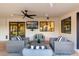Covered patio area has ample seating, a ceiling fan, and a TV for outdoor entertaining with indoor-outdoor flow at 5642 E Justine Rd, Scottsdale, AZ 85254
