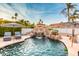 Backyard pool featuring a rock waterfall, lounge chairs, and tropical landscaping at 5642 E Justine Rd, Scottsdale, AZ 85254