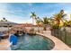 Backyard oasis featuring a sparkling pool, rock waterfall, and lush desert landscaping at 5642 E Justine Rd, Scottsdale, AZ 85254