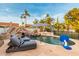 Backyard pool with a rock waterfall, spa, sun loungers, and tropical landscaping for relaxation at 5642 E Justine Rd, Scottsdale, AZ 85254
