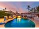 Backyard swimming pool featuring a rock waterfall, sun umbrellas, and lounge chairs in a private tropical setting at 5642 E Justine Rd, Scottsdale, AZ 85254