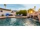 The backyard pool has a rock waterfall feature, poolside lounge chairs, and an umbrella for shaded relaxation at 5642 E Justine Rd, Scottsdale, AZ 85254