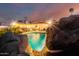 Inviting backyard pool with waterfall feature and rock accents, perfect for relaxation and entertaining on a beautiful night at 5642 E Justine Rd, Scottsdale, AZ 85254