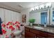 Bright bathroom with a granite countertop, modern lighting, and a tub with a floral shower curtain at 5877 N Granite Reef Rd # 1155, Scottsdale, AZ 85250