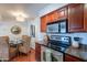 Bright kitchen with stainless steel appliances, granite countertops, and cherry-wood cabinets at 5877 N Granite Reef Rd # 1155, Scottsdale, AZ 85250
