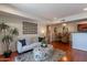 Well-lit living room featuring stylish sofa, ottoman, and access to the dining area, with hardwood floors at 5877 N Granite Reef Rd # 1155, Scottsdale, AZ 85250