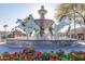 Artistic horse statues in water fountain surrounded by vibrant red flowers and retail shops at 5877 N Granite Reef Rd # 1155, Scottsdale, AZ 85250