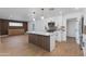 Bright kitchen with island flows into a living space with custom wood accent wall and cabinets, wood-look floors at 7507 E Beatrice St, Scottsdale, AZ 85257