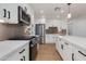 Modern kitchen with stainless steel appliances, gas range, white cabinetry, and a marble countertop island at 7507 E Beatrice St, Scottsdale, AZ 85257