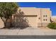 Beige home exterior with two-car garage, manicured landscaping, and a well-maintained sidewalk at 9070 E Gary Rd # 136, Scottsdale, AZ 85260
