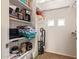 Organized walk-in closet featuring shelving with various household items, a vacuum, and hanging clothes racks at 9070 E Gary Rd # 136, Scottsdale, AZ 85260