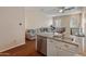 Open-concept kitchen with granite countertops, white cabinets, stainless steel appliances, and adjacent living area at 927 W Wendy Way, Gilbert, AZ 85233