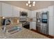 Bright kitchen featuring stainless steel appliances, granite countertops, white cabinets, and a modern chandelier at 927 W Wendy Way, Gilbert, AZ 85233