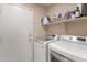 Functional laundry room equipped with modern washer and dryer units, plus shelving for storage at 927 W Wendy Way, Gilbert, AZ 85233