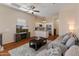 Cozy living room with a comfortable gray sofa, ceiling fan, a stylish rug, and a view into the kitchen at 927 W Wendy Way, Gilbert, AZ 85233