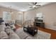 Comfortable living room with a large sofa, ceiling fan, a stylish rug, and a view of the staircase at 927 W Wendy Way, Gilbert, AZ 85233