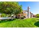 Spacious backyard featuring a healthy lawn, an orange tree, covered patio, and a sparkling blue pool at 930 E Citation Ln, Tempe, AZ 85284