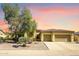 Charming home featuring desert landscaping, a two-car garage, and a beautiful sunset sky at 12733 S 177Th Ln, Goodyear, AZ 85338
