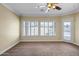 A bright main bedroom featuring carpet flooring, plantation shutters, ceiling fan, and private outdoor access at 12733 S 177Th Ln, Goodyear, AZ 85338