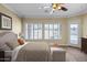 A spacious main bedroom featuring a large bed, ceiling fan, plantation shutters and private outdoor access at 12733 S 177Th Ln, Goodyear, AZ 85338