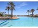 Resort-style pool featuring palm trees, lounge chairs, and a beautiful lake view for ultimate relaxation at 12733 S 177Th Ln, Goodyear, AZ 85338