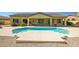 Inviting backyard pool with a baja shelf surrounded by desert landscaping, perfect for relaxation and outdoor entertaining at 12733 S 177Th Ln, Goodyear, AZ 85338