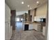 Partially renovated kitchen featuring white cabinets, black appliances, and an open layout to the living room at 3871 E Ironhorse Rd, Gilbert, AZ 85297