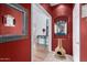 A vibrant entryway featuring textured red walls, eclectic decor, and contrasting flooring at 10322 E Excavation Ct, Gold Canyon, AZ 85118