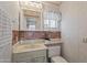 Cozy bathroom featuring red brick backsplash, decorative wallpaper, and vanity with storage at 111 S Greenfield Rd # 313, Mesa, AZ 85206