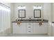 Bathroom features a dual sink vanity, sleek, dark countertops and modern fixtures at 11835 W Windsor Ave, Avondale, AZ 85392