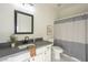 Nicely appointed bathroom features granite counters and a shower/tub combination with curtain at 11835 W Windsor Ave, Avondale, AZ 85392